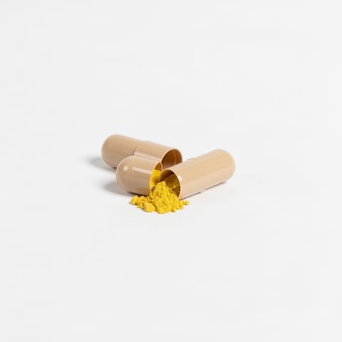 Moringa Pure supplement bottle with capsules spilled out