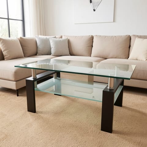 A glass coffee table with a black frame and silver accents in a living room