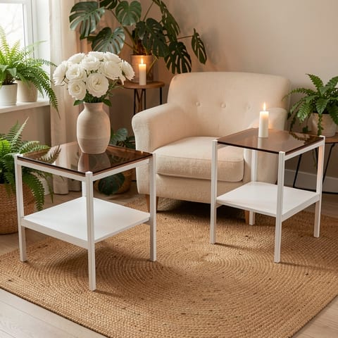 Two brown glass and white metal end tables next to a beige couch.