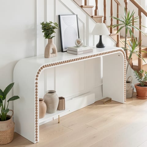 White console table with curved waterfall-style edge and wood beads