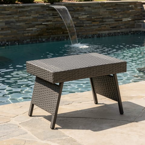 Wicker snack table by a pool with a waterfall feature