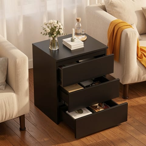 Black 3-drawer nightstand with drawers open, next to a white armchair.