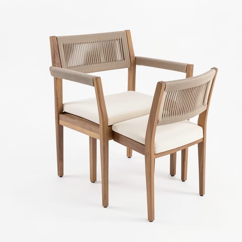 Four braided acacia wood outdoor dining chairs with beige rope and cream cushions on a wooden deck beside a pool.