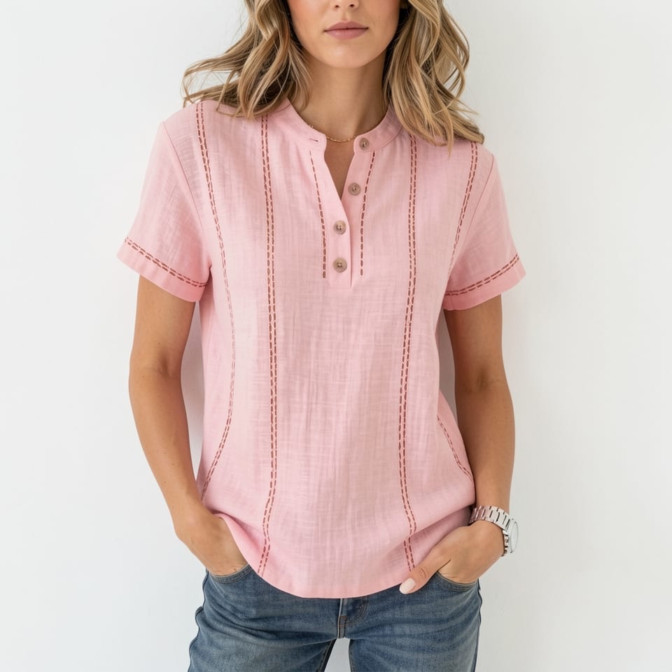 Woman wearing a pink short-sleeve shirt with vertical stitching and buttons